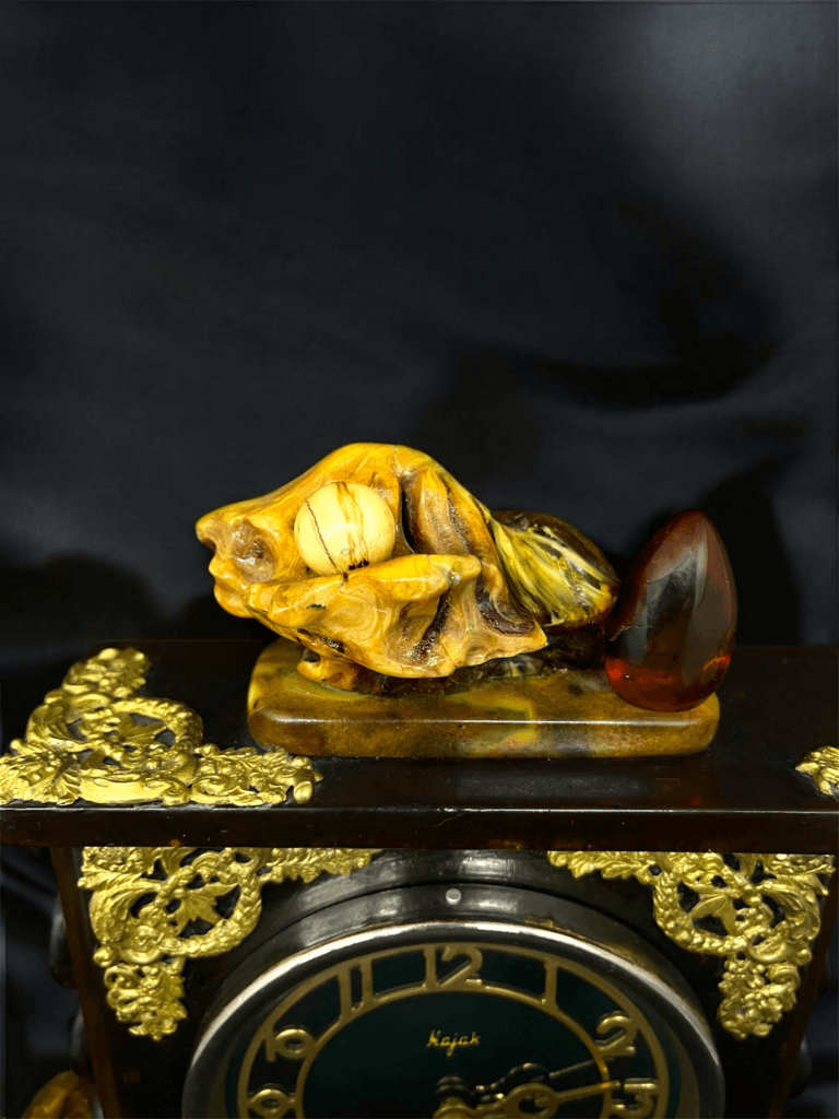 Amber Time Symphony: Close-up of the amber-crafted clock adorned with a shell-shaped gemstone and natural amber nugget