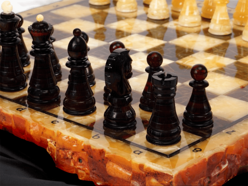 Amber Royal Chess close-up – dark amber chess pieces on a handcrafted amber chessboard